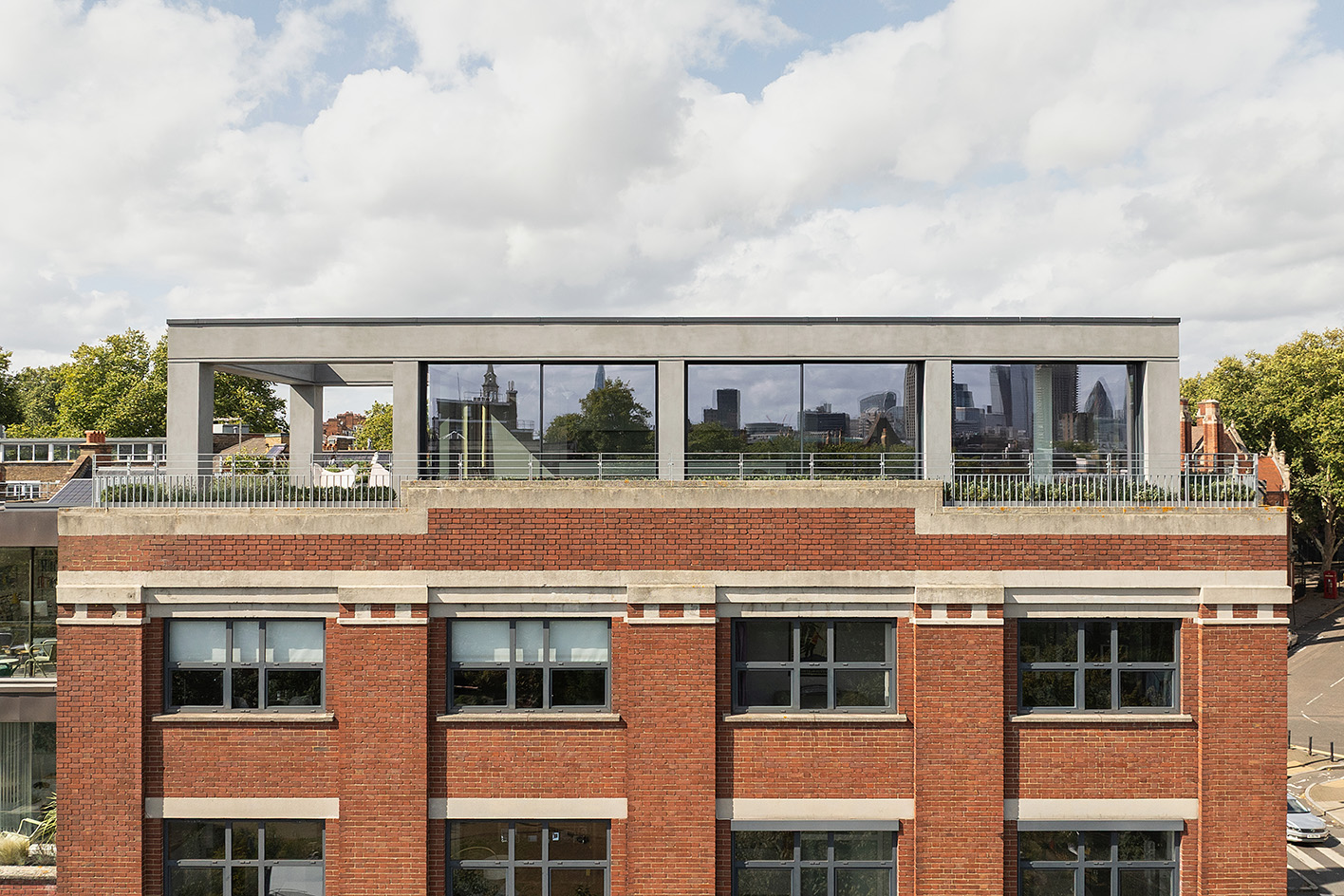 Clerkenwell Rooftop apartment in London, showing minimalist concrete and large openings with terrace and views out to urban views with green