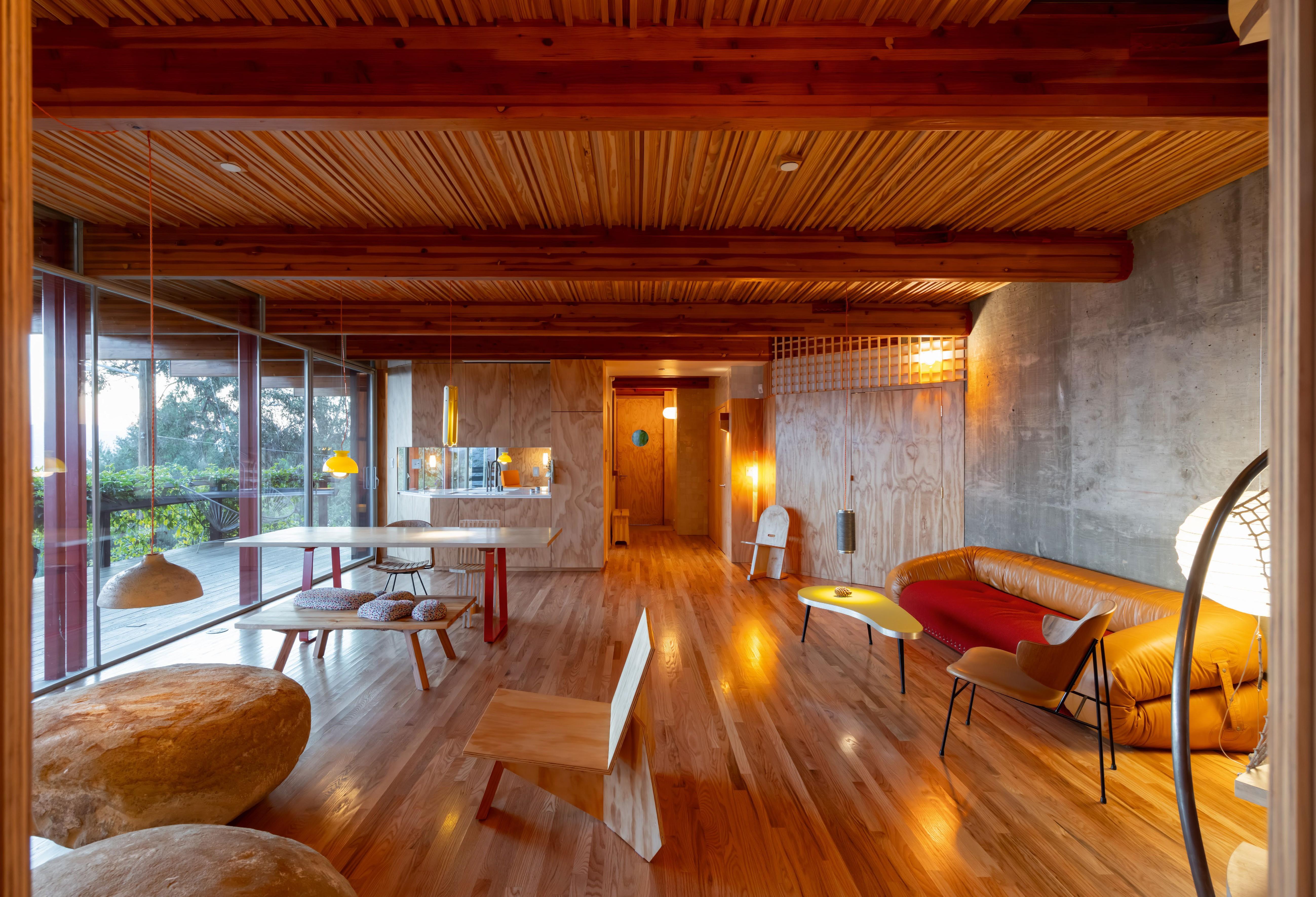 Cano house, a colourful Los Angeles home, seeing here interior of the living space with timber floor and ceiling